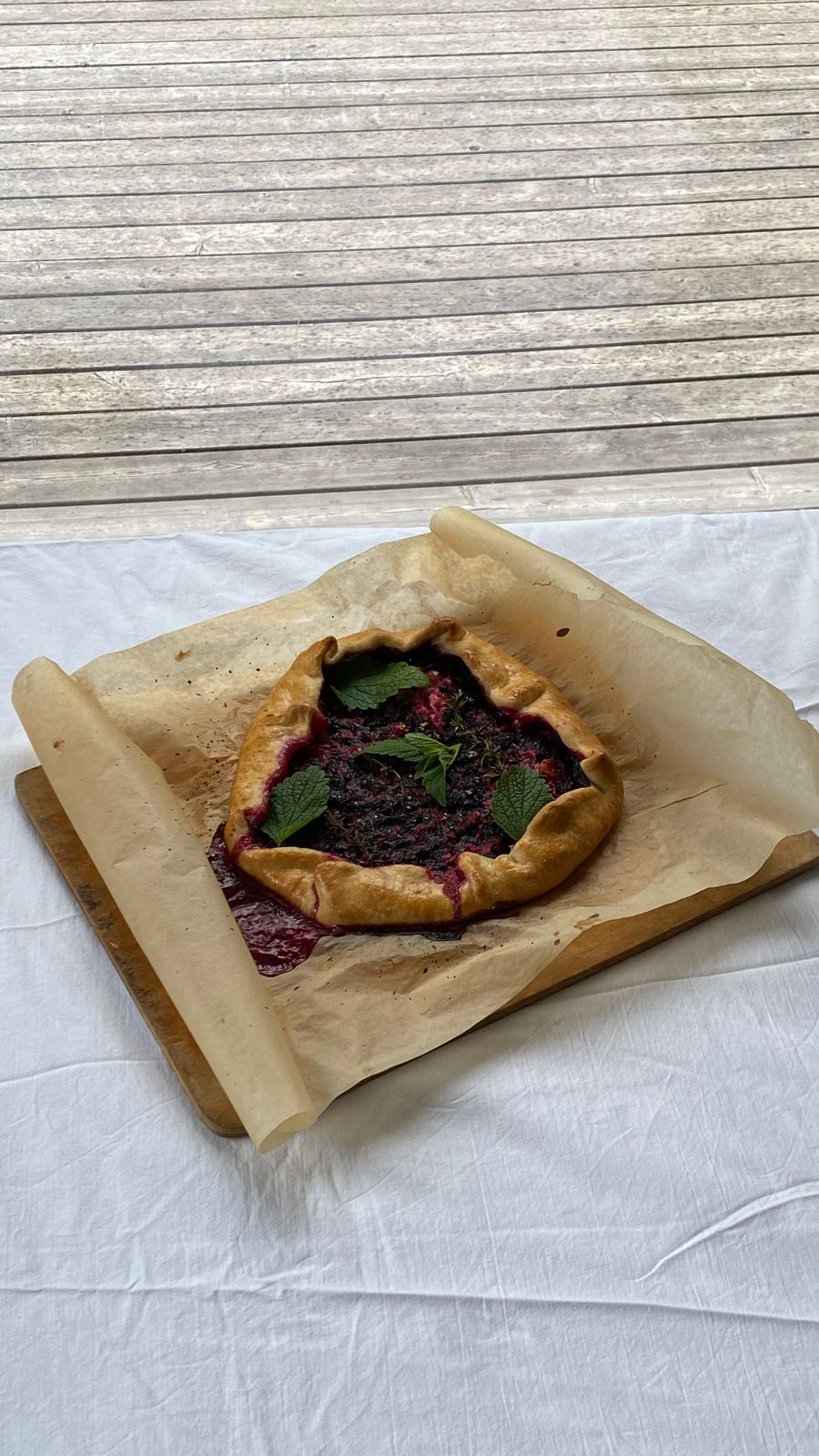A handmade berry galette with a folded pastry crust on parchment.