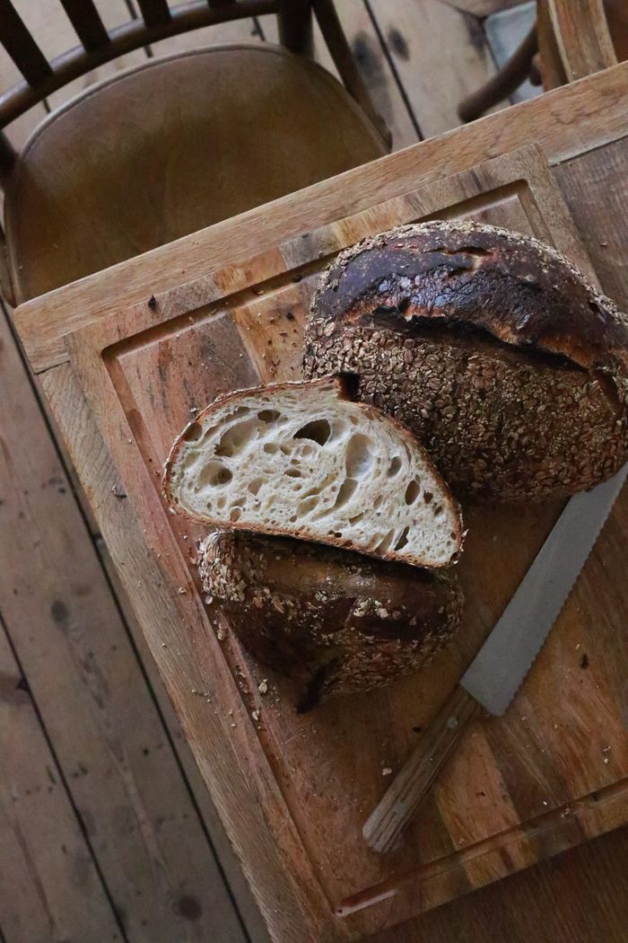 Sliced country sourdough with an open crumb on a wooden board.
